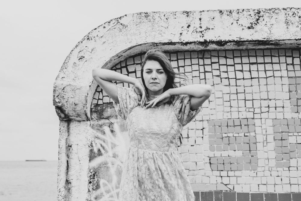 Black and white portrait against brick wall with vintage aesthetic.