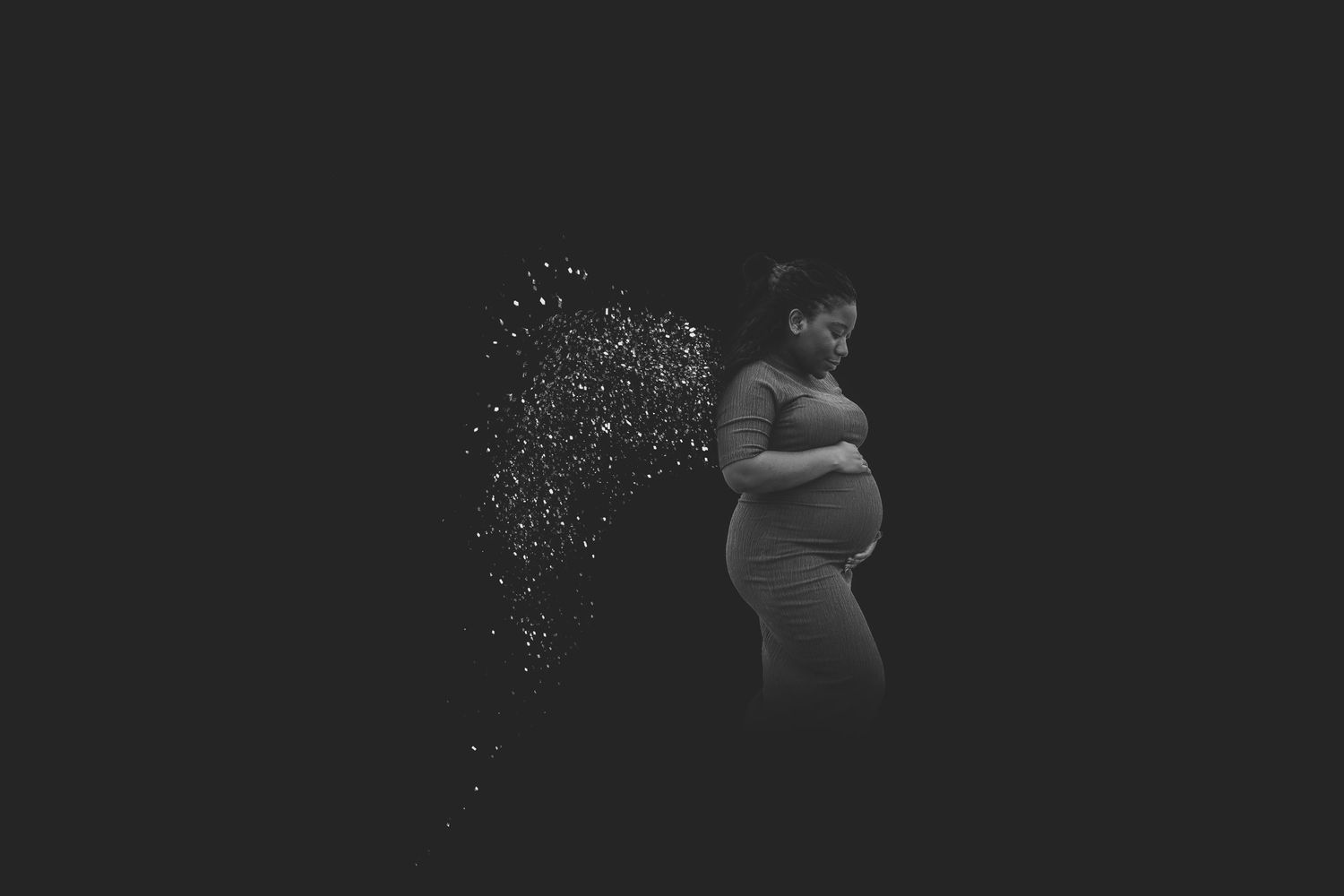 Silhouetted maternity portrait with sparkles against dark background. Photographer. Hull. East Yorkshire. Photography
