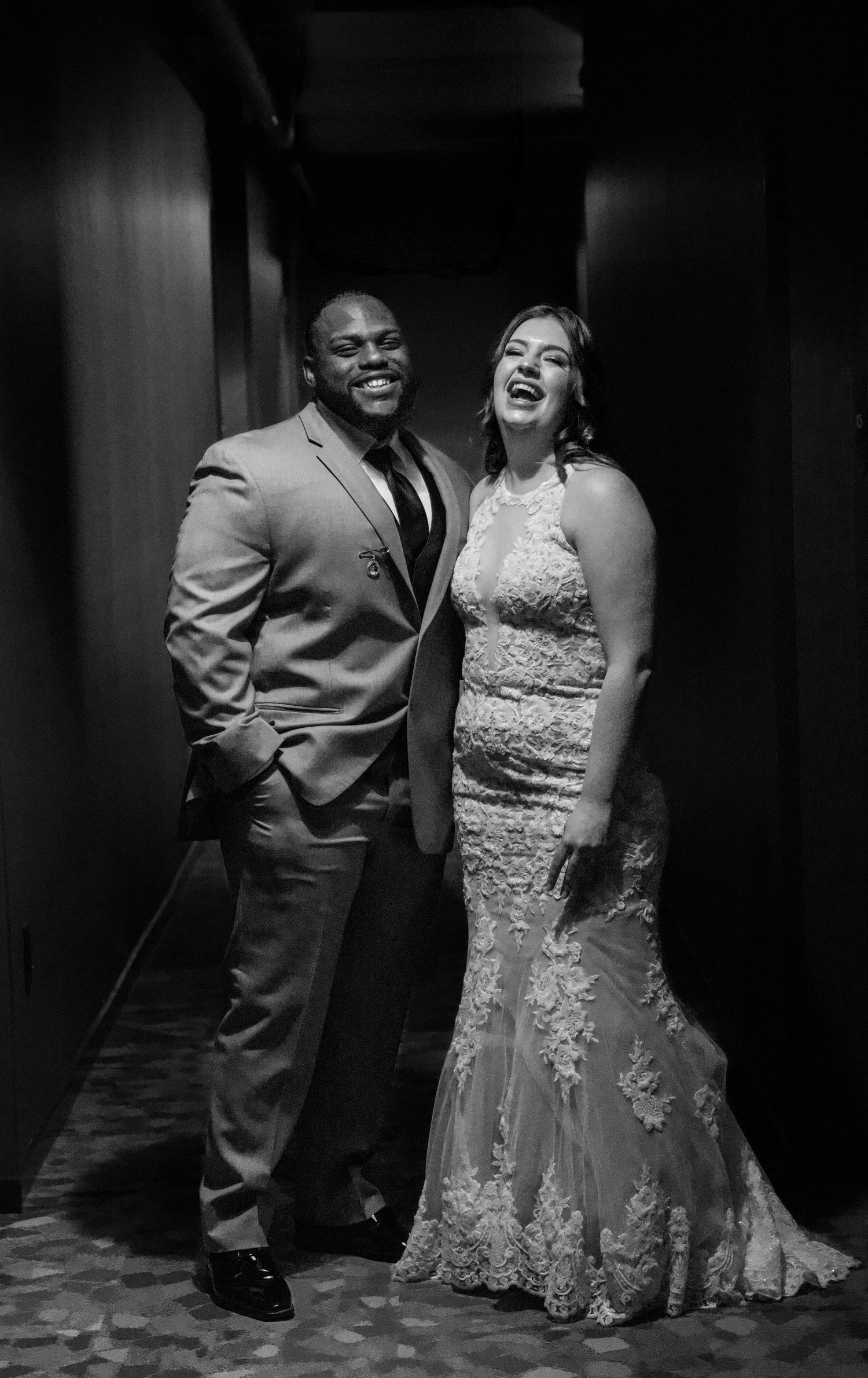 A formal black and white portrait of a couple in elegant evening attire.