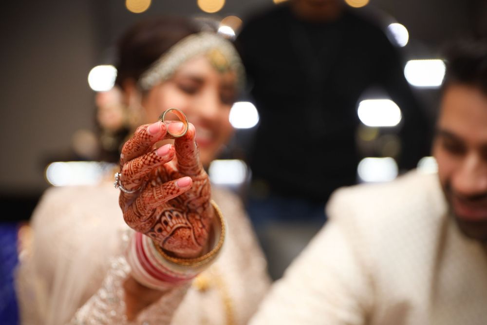 Close-up of henna-decorated hands during traditional Indian wedding ceremony. Hindu Wedding Photography