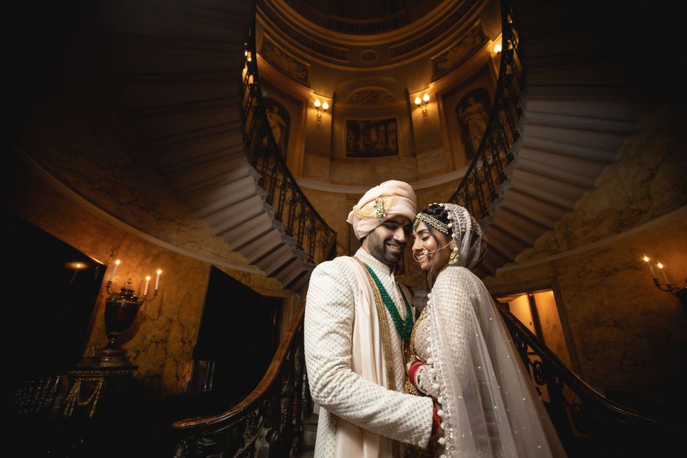 Romantic wedding moment captured under ornate domed ceiling with dramatic lighting. Asian Wedding Photography & Videography
