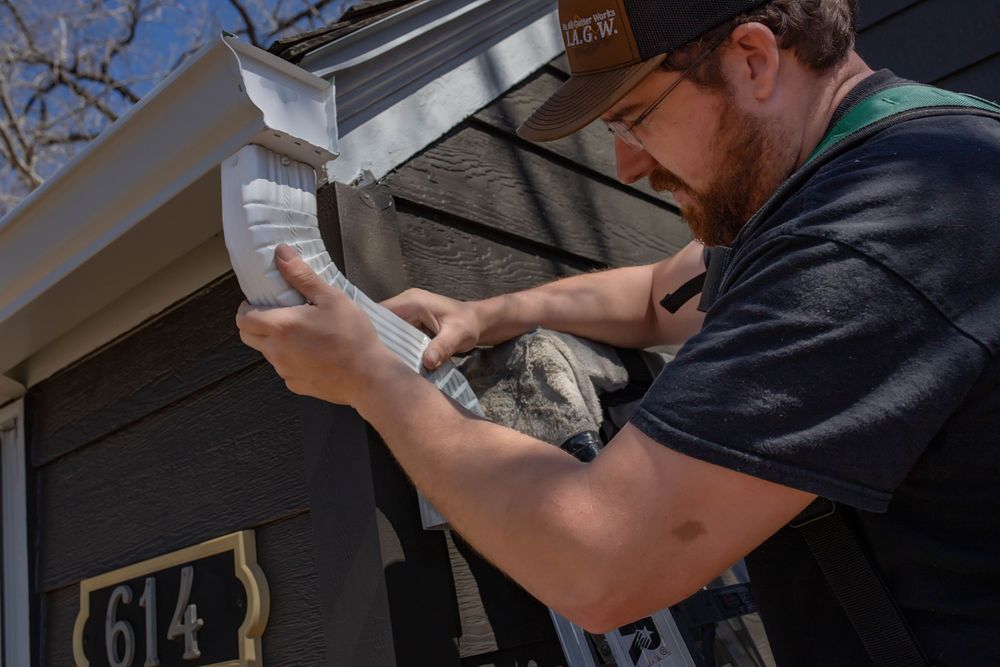 Maintenance worker inspects paperwork while working on home repairs outside a residential property.