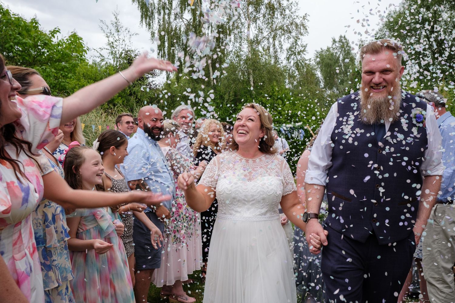A joyful wedding party shares a confetti moment
