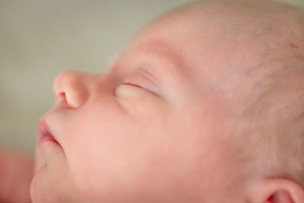 A close-up series of a baby's face showing various angles and expressions in soft lighting.