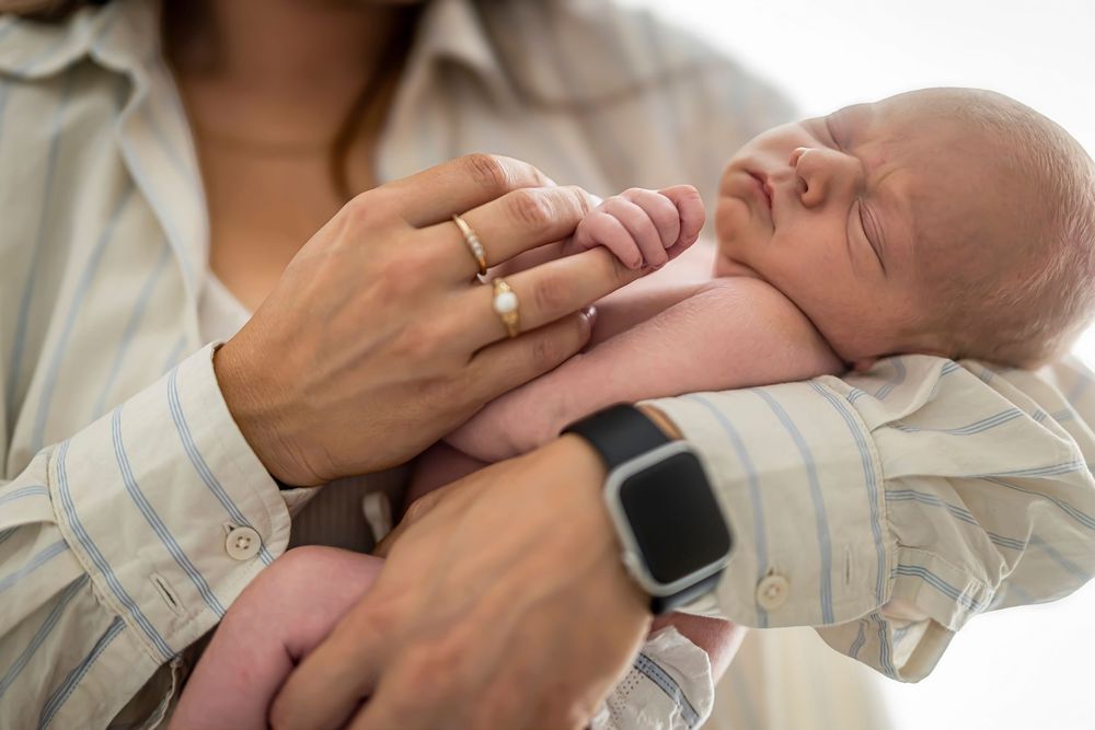 Tender moment between parents and newborn baby in close-up shots showing gentle touches and bonding.