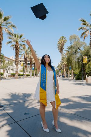 A series of graduation photos showing joyful celebration poses on a palm tree-lined campus walkway in bright sunlight.