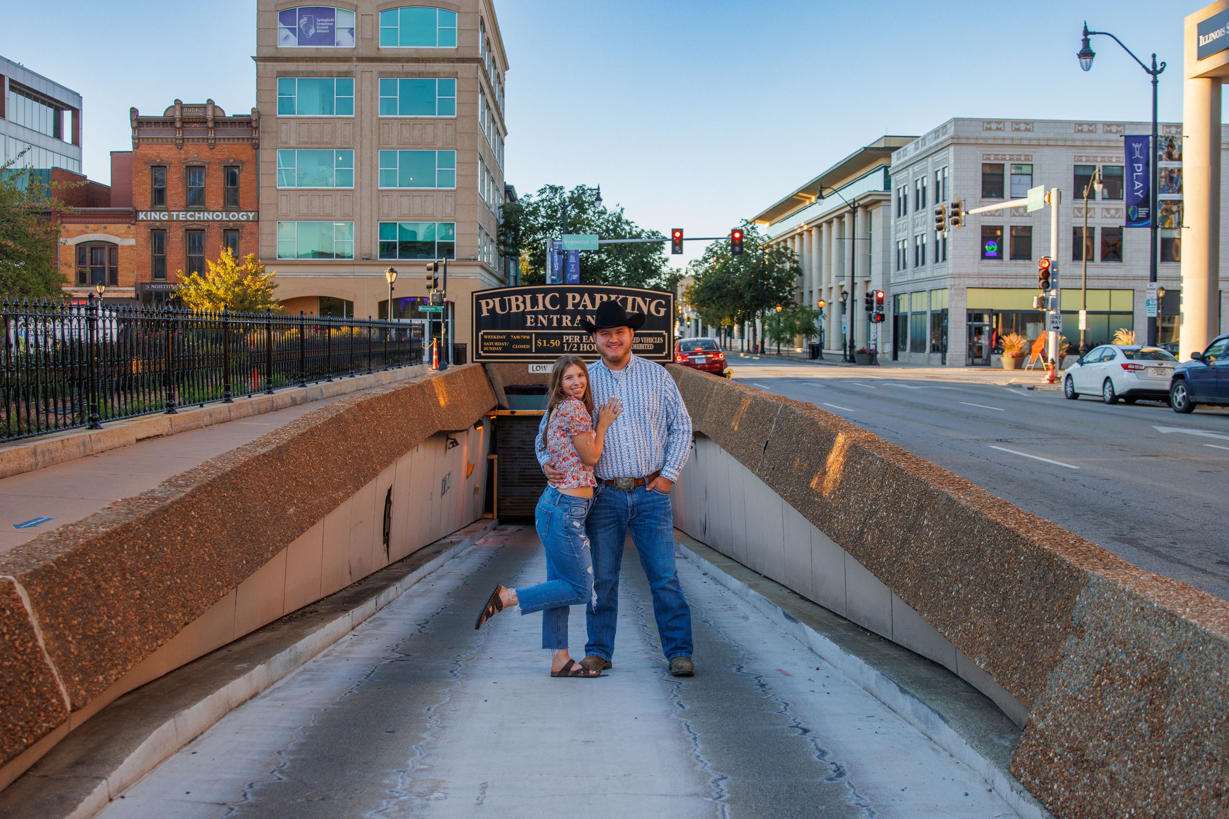Couples walking along historic downtown sidewalk during sunset.
