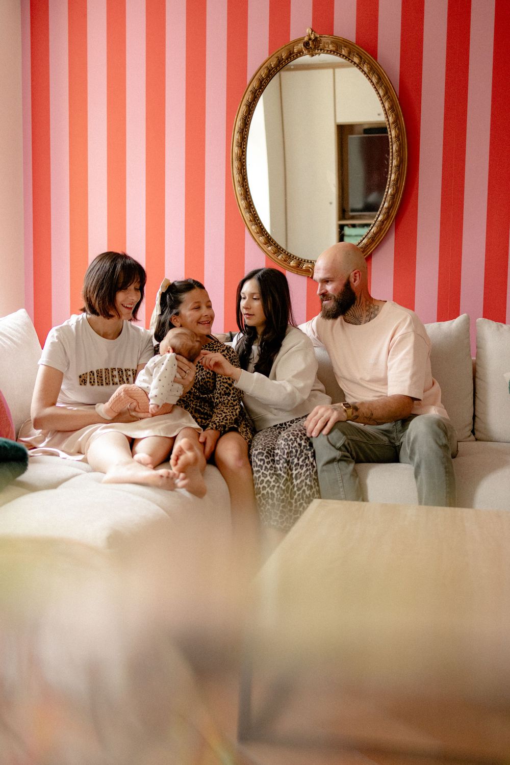 A group lounges on a white couch against a red and white striped wall in a candid photo sequence.