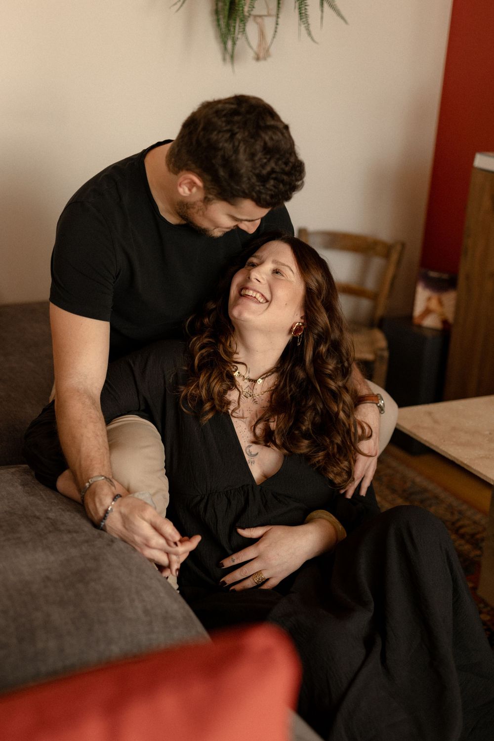 A couple shares intimate moments on a couch in a series of romantic lifestyle photographs.