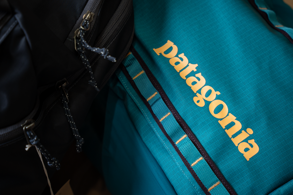 Detail shot of Patagonia logo embroidered in gold on teal outdoor gear.