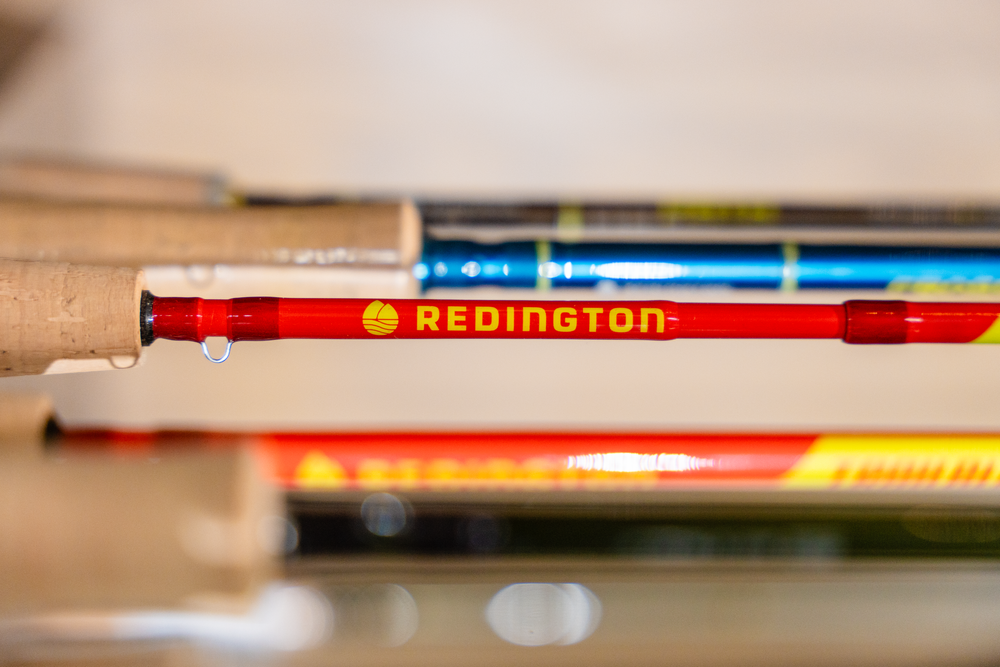 Close-up view of a red Redington pencil or pen among other writing instruments.