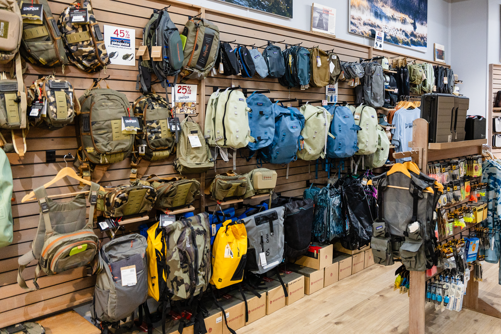 Display wall of outdoor backpacks and gear bags in various colors and sizes.