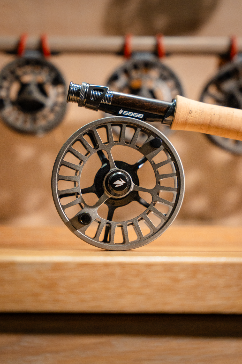 Close-up of a modern fly fishing reel with cork handle mounted on display.