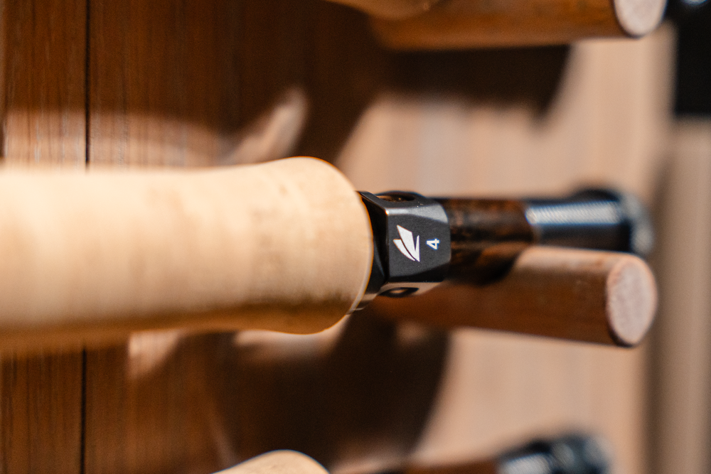 Detail shot of a fly fishing rod handle with cork grip and reel seat.