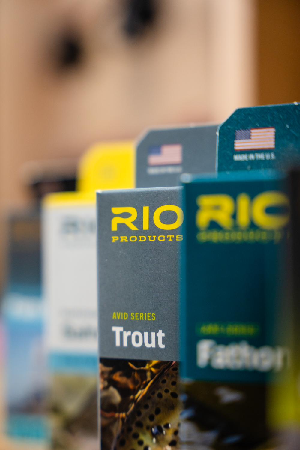 Selective focus shot of RIO Products fly fishing line boxes featuring trout fishing gear.