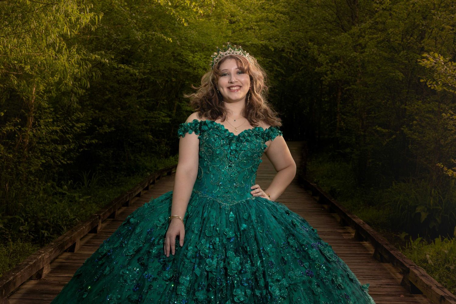 Stunning green formal dress photographed on rustic wooden walkway.