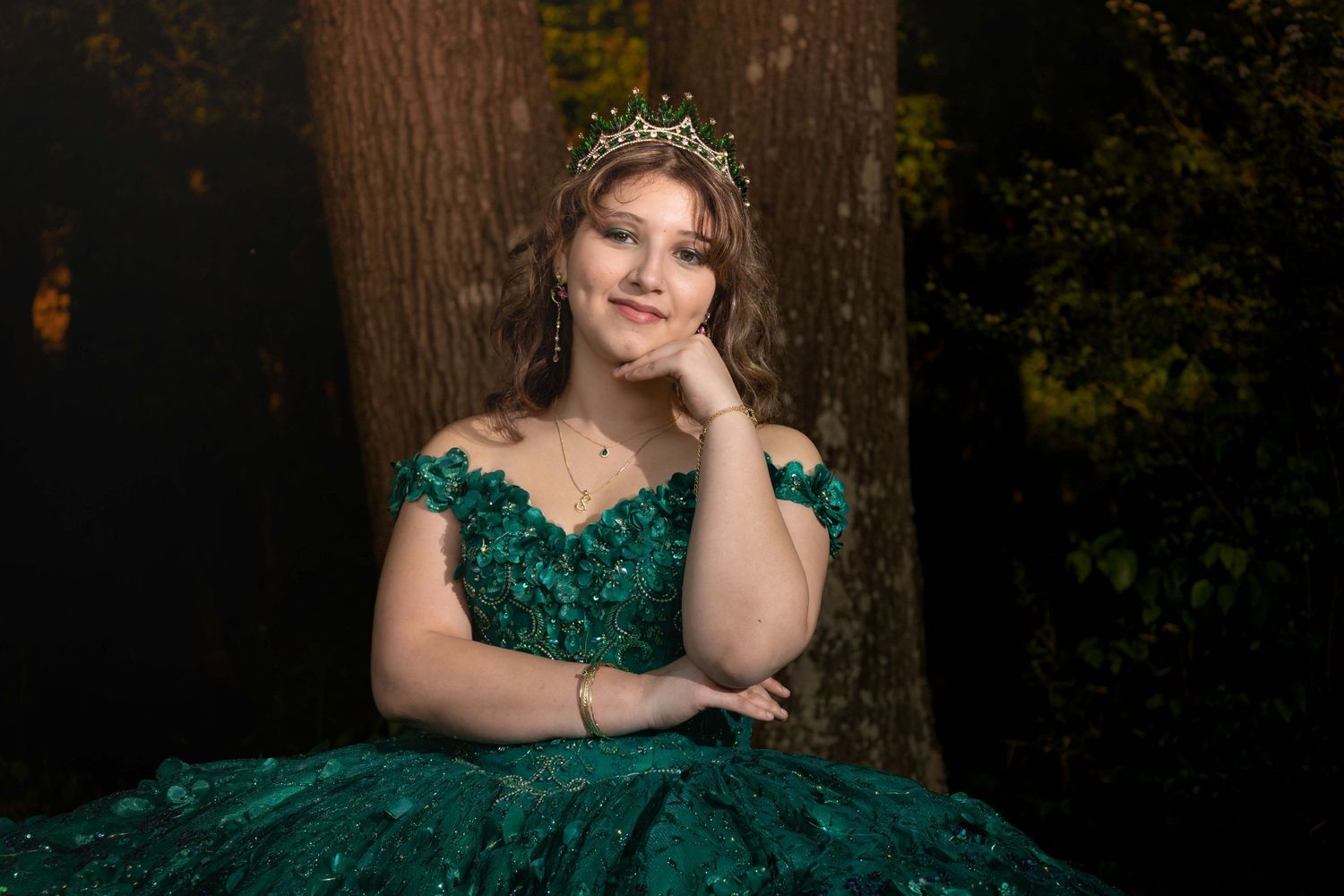 Enchanting forest photoshoot featuring a stunning emerald green princess gown.