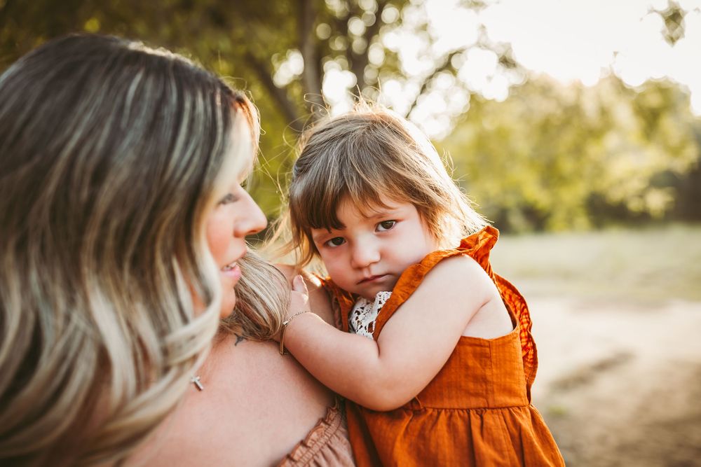 A tender moment shared between parent and child at sunset in a golden field.