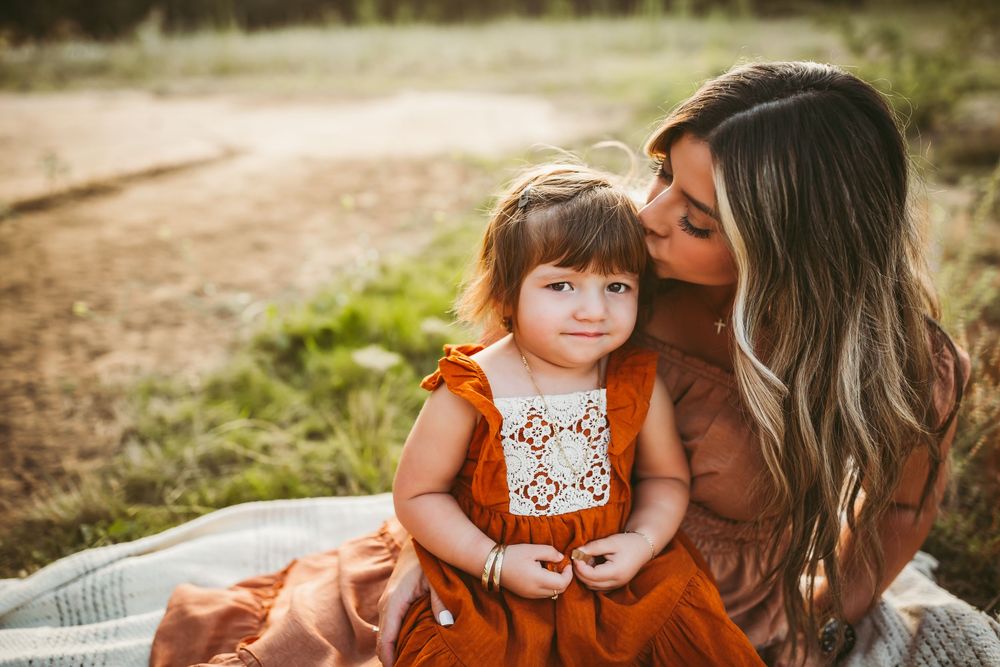 A heartwarming family moment captured outdoors with warm autumn colors and natural lighting.