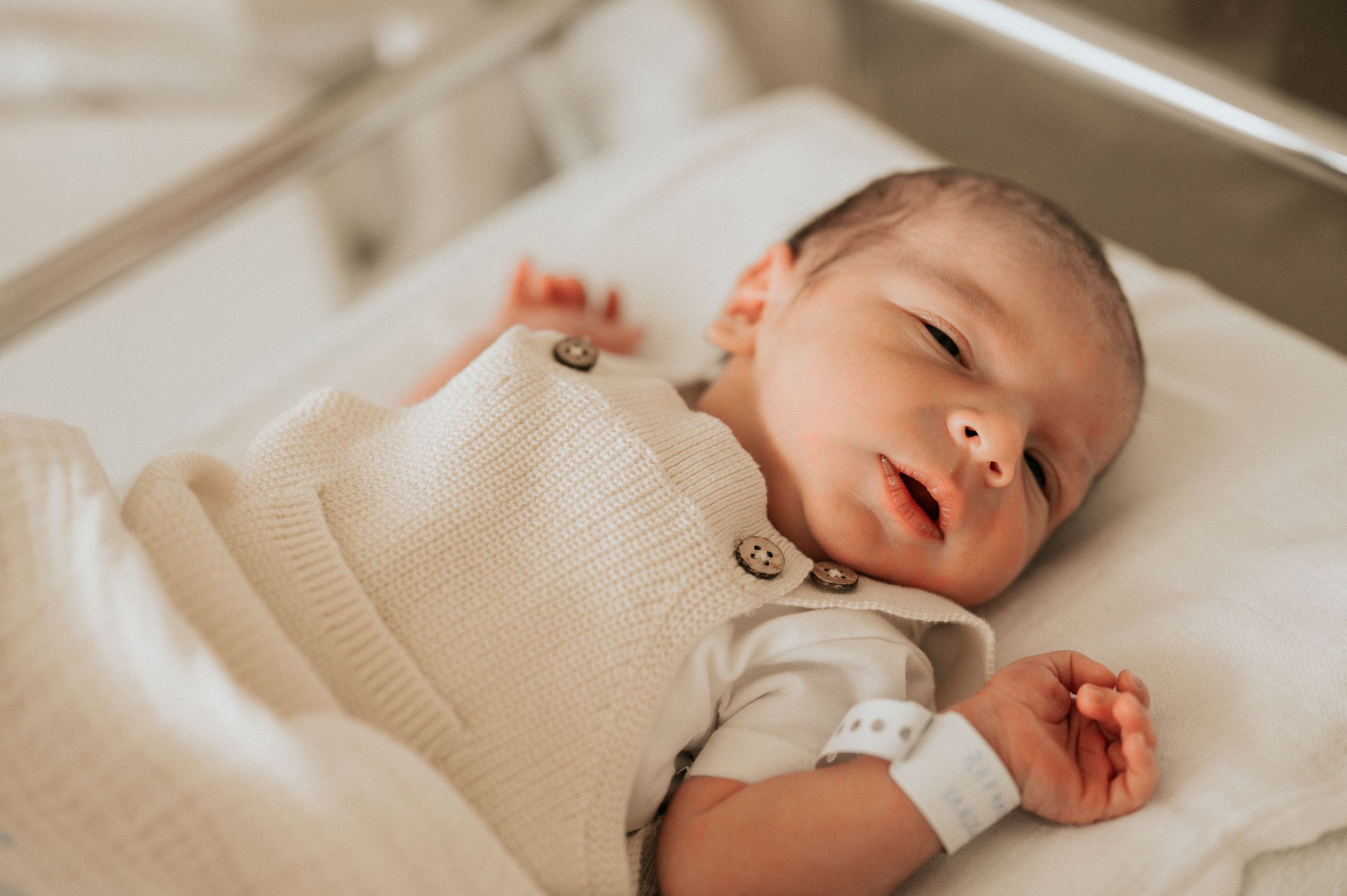 Een slapende baby tijdens een fresh 48 in het ziekenhuis van AZ Delta Roeselare in neutrale warme bewerkingsstijl met details.