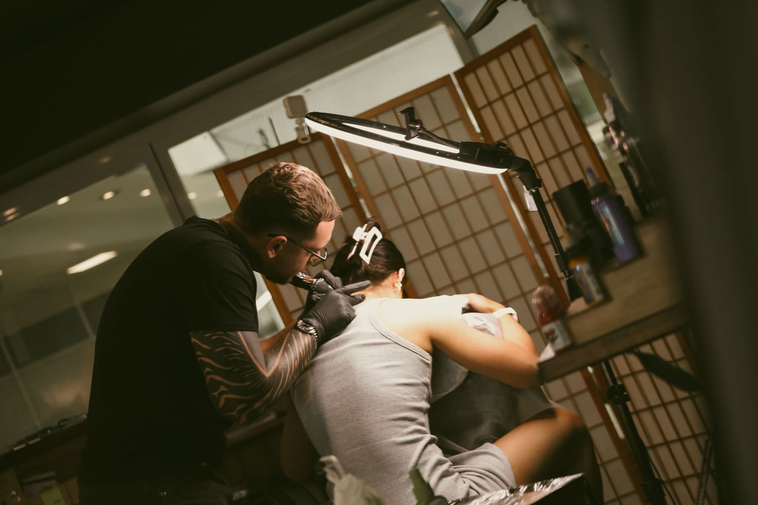 A couple in an intimate dance pose with dramatic lighting and shadows in a rustic wooden interior setting.