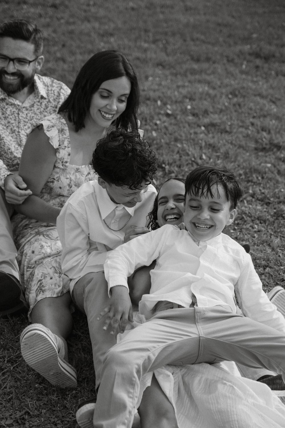 Black and white candid family photo showing playful interaction outdoors.