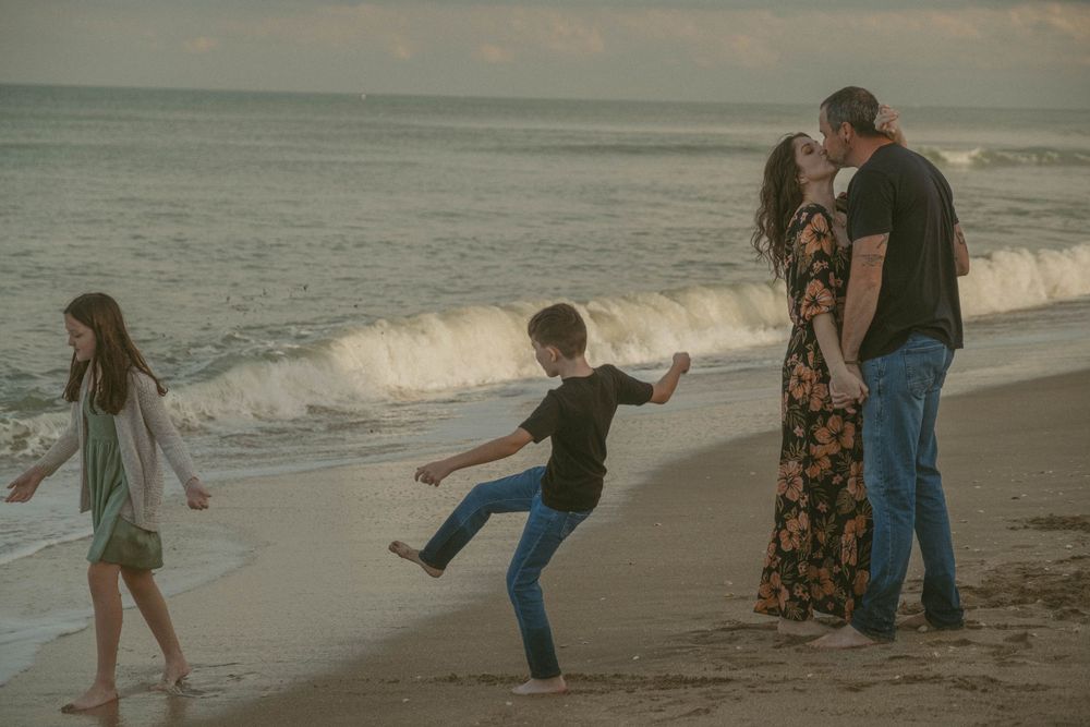 Group enjoying playful moments along the beach at sunset.