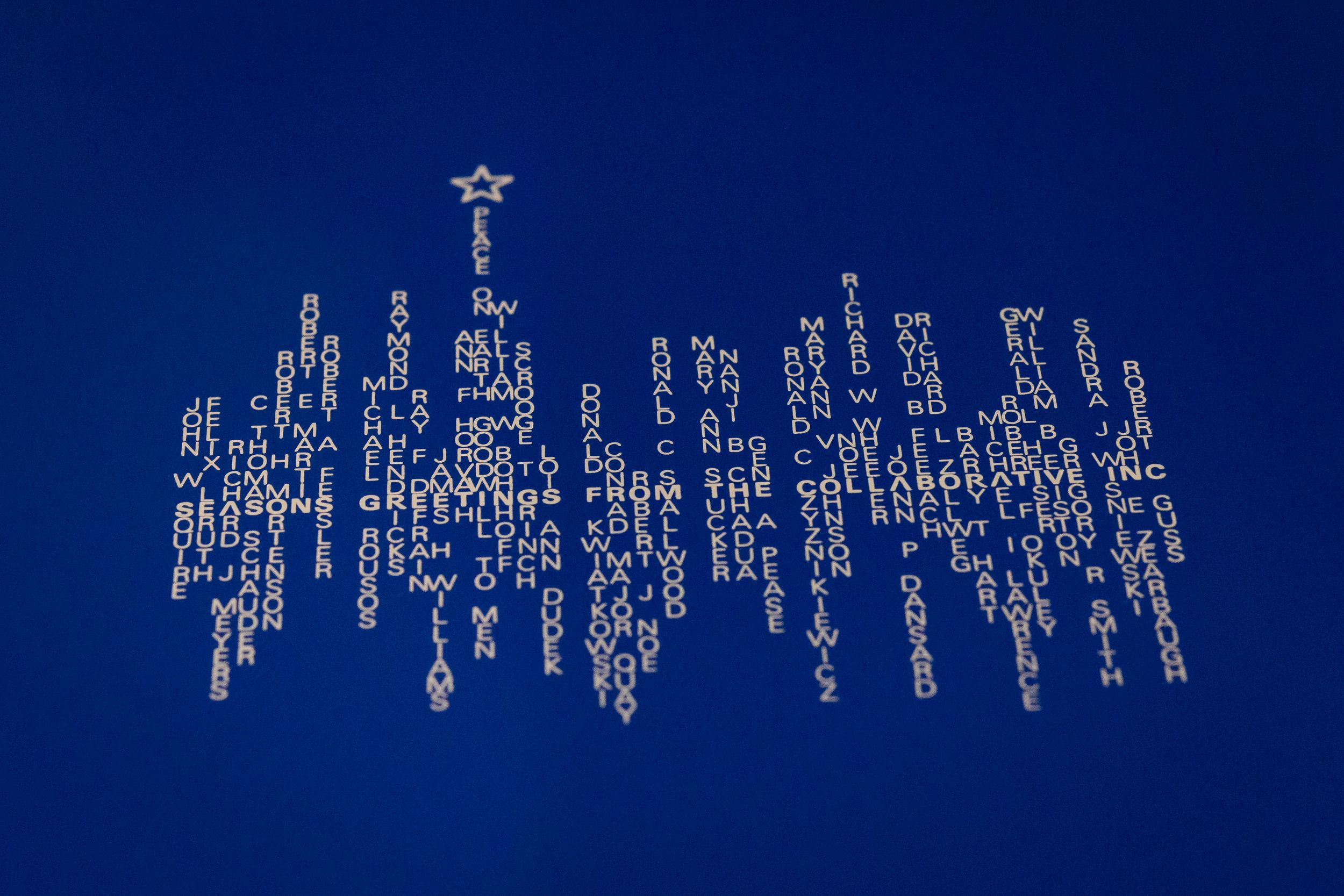 A large decorative holiday light display resembling a chandelier glows brightly against a deep blue night sky.