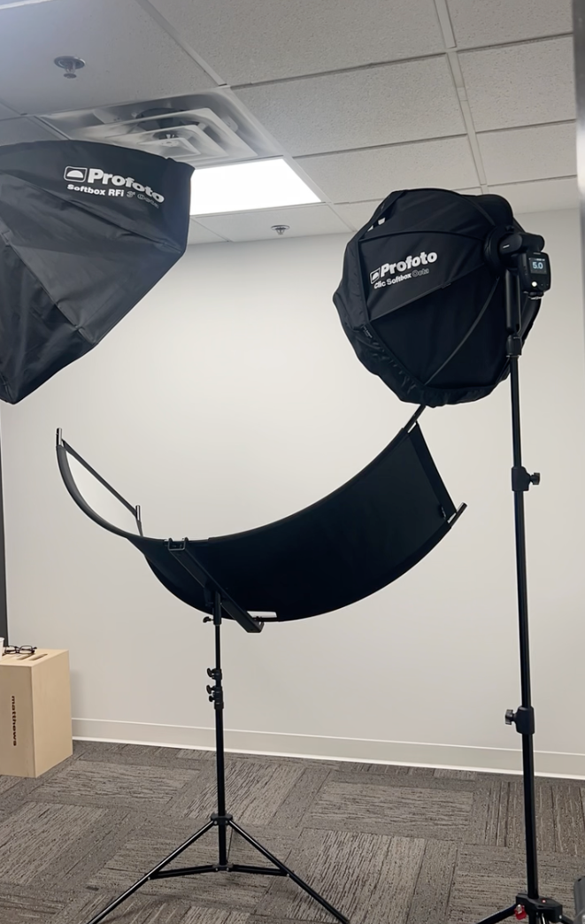 Portrait photography studio equipment including Profoto lighting gear, softboxes, and a silver curved reflector on stands at J Sanchez Photo