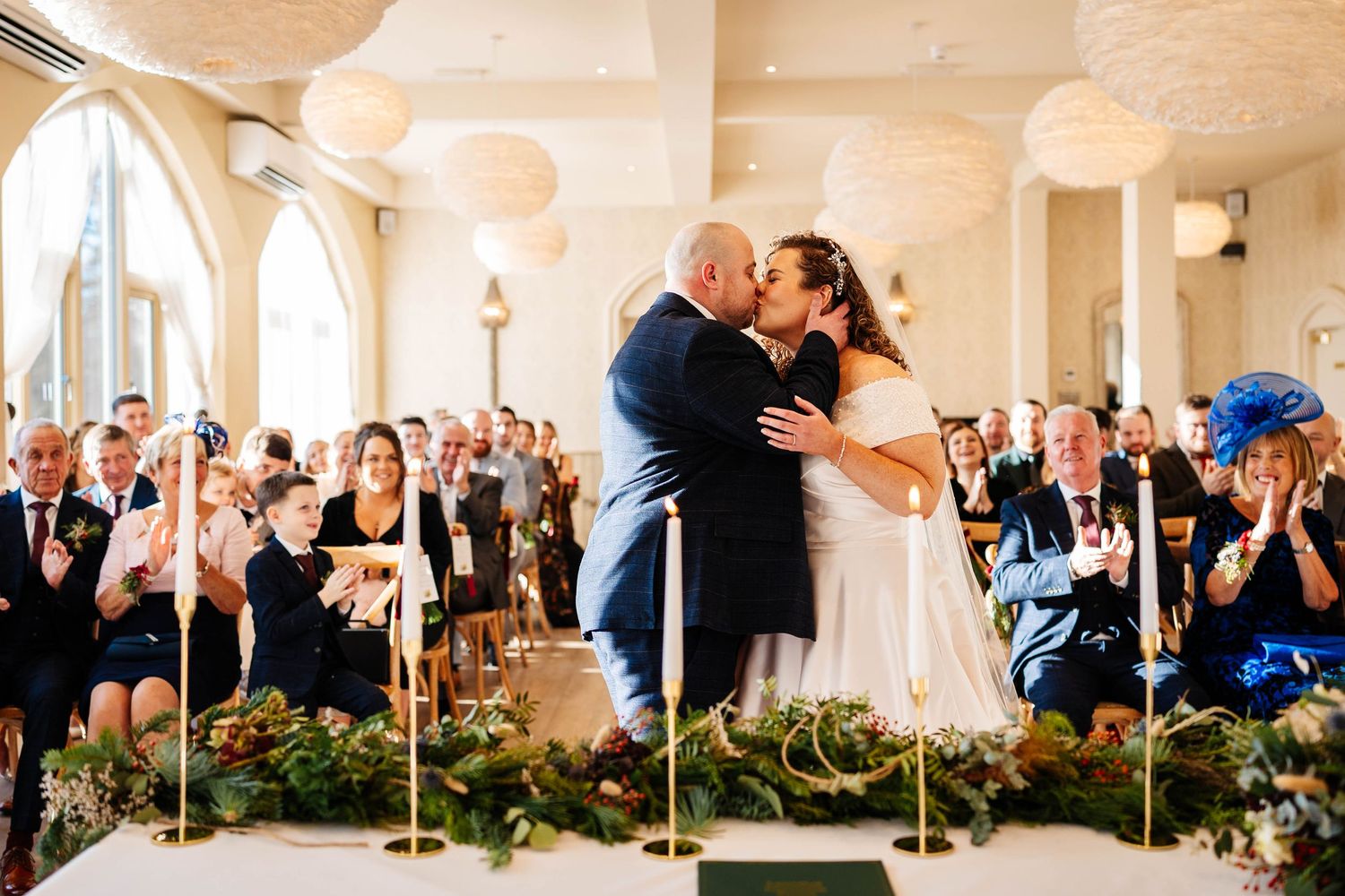 Bride & Groom share their first kiss during ceremony held at Wennington Hall. A Winter Wedding captured by Lynette Matthews Photography