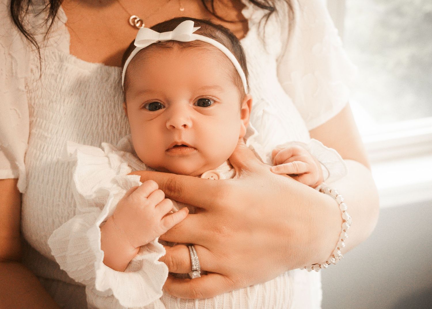 A tender family moment captured in a series of intimate photographs showing parents bonding with their newborn at lifestyle photo session.