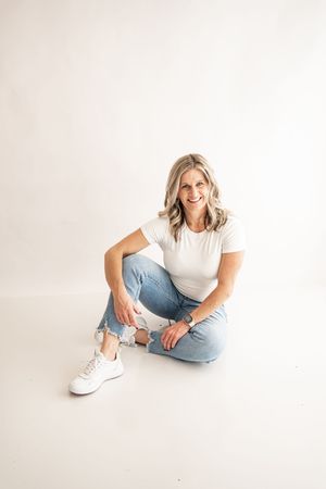 Person in casual white t-shirt and light jeans sitting on floor against white background in three relaxed poses.