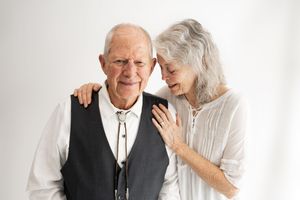 Elderly couple in white and black attire share tender moments across four connected photos.