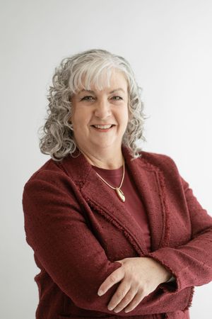 Person wearing a burgundy sweater smiles warmly against a white background in a series of candid poses.