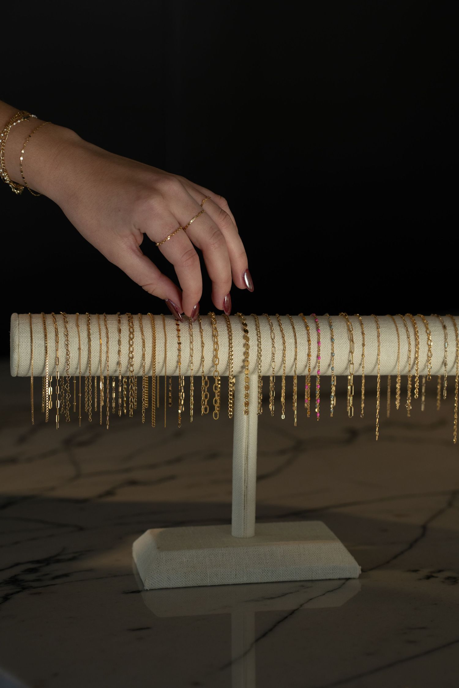A series of images showing a person's hand picking up bracelets