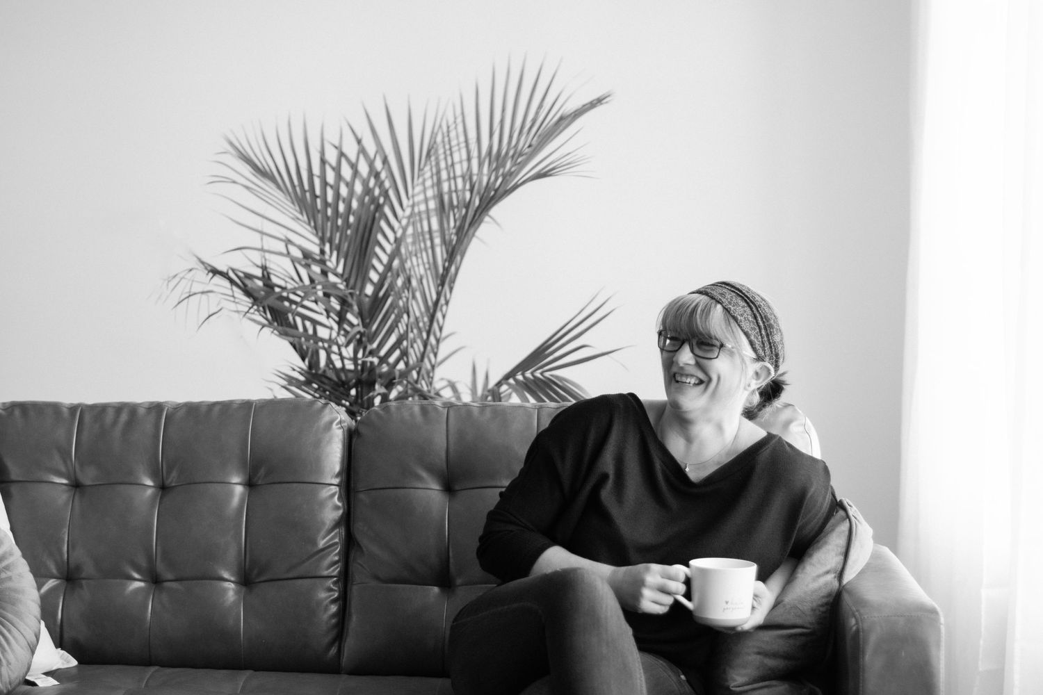 A series of five photos showing someone in a black shirt drinking from a white coffee mug while sitting on a brown couch.