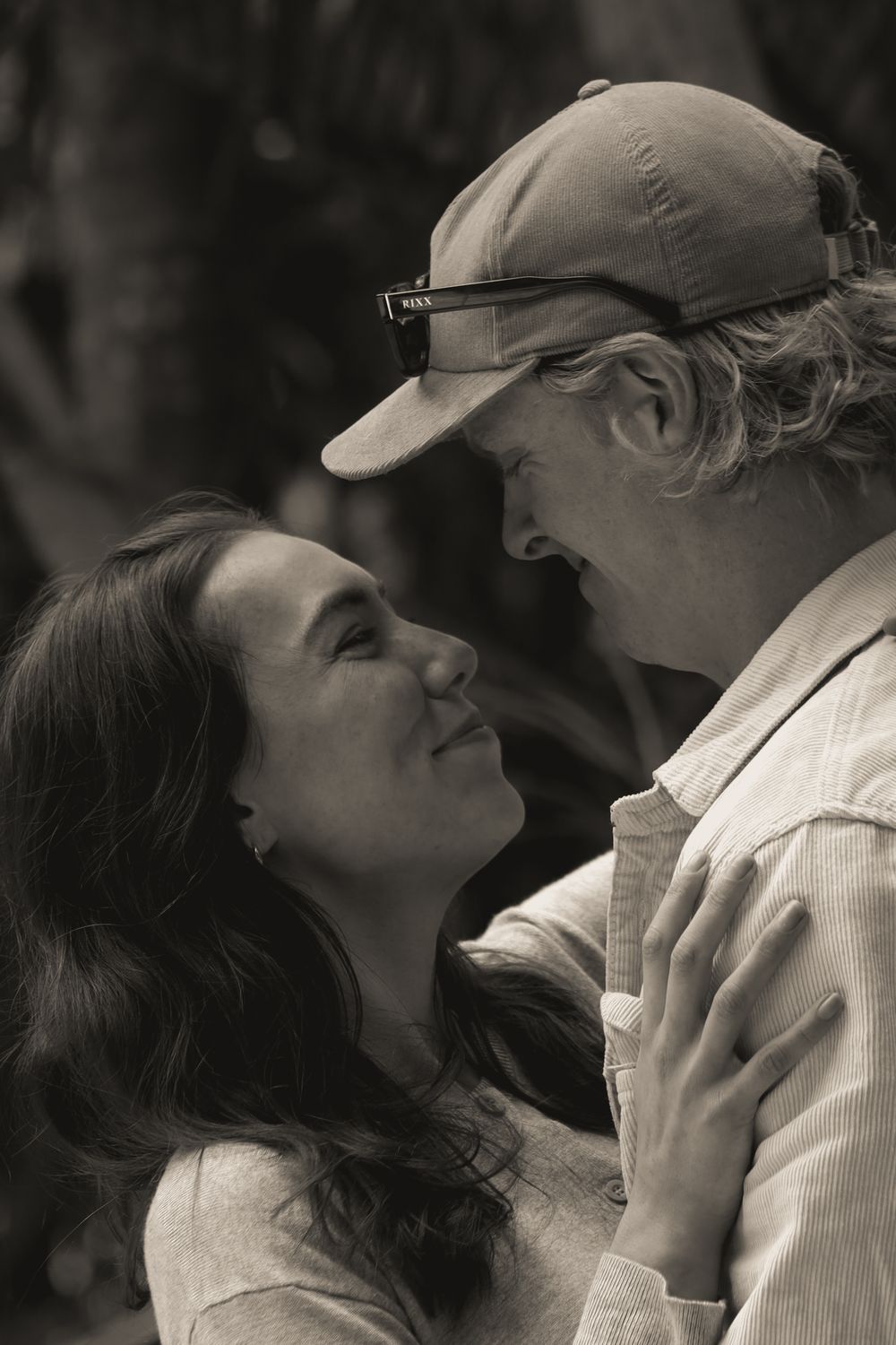 A romantic black and white photo series showing a couple sharing intimate kisses from different angles.