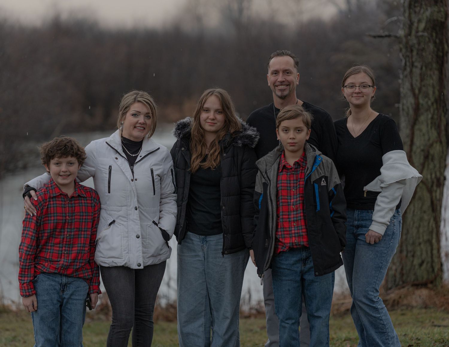 A group photo of family members standing together outdoors on a cloudy day.