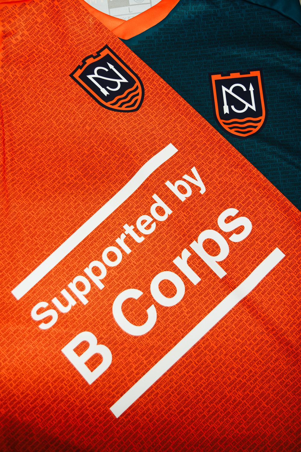 Close-up detail shots of orange and teal soccer jerseys with B Corps branding and white text.