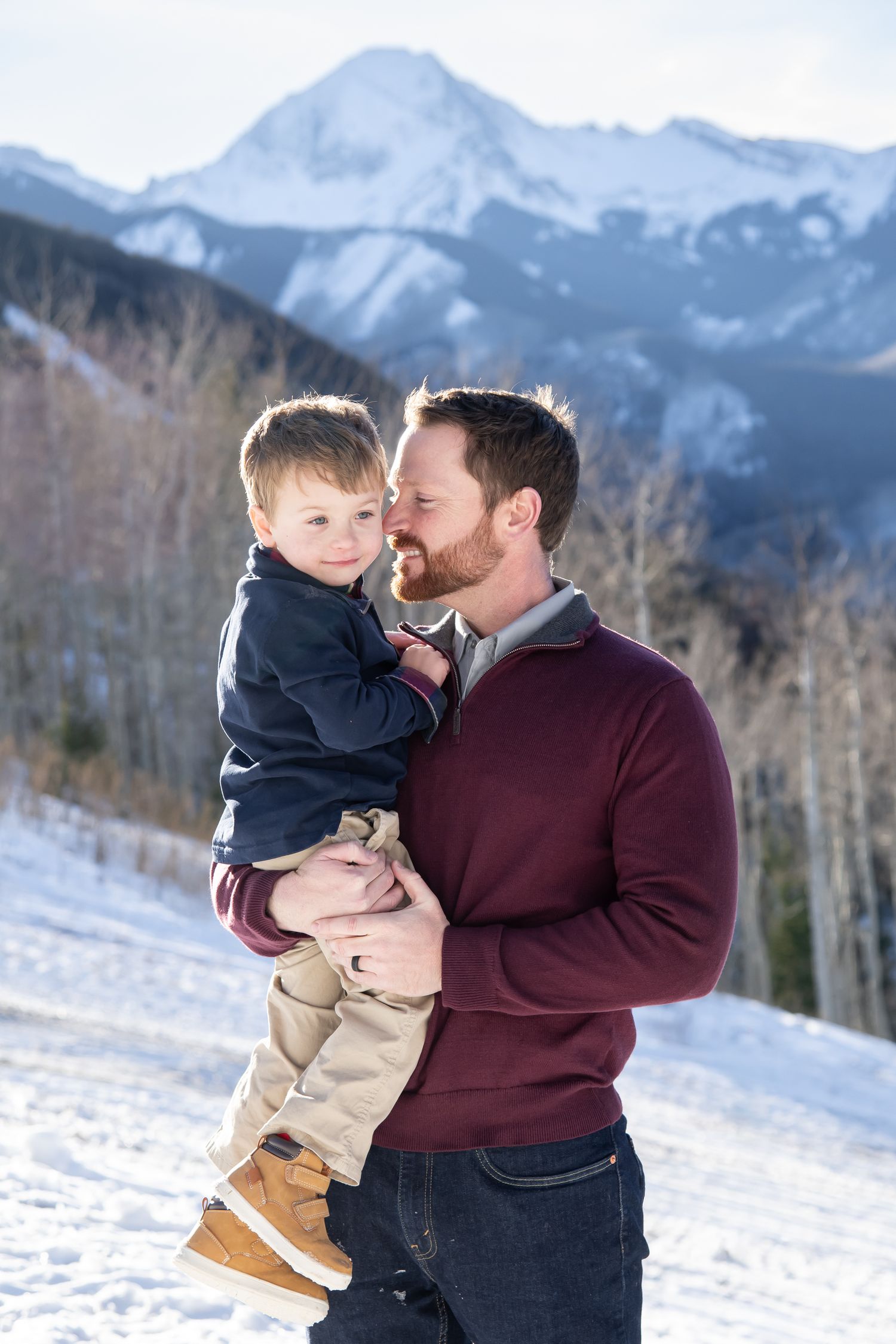 Cute candid family photo in Aspen Colorado with a winter landscape of snowy mountain peaks in the background