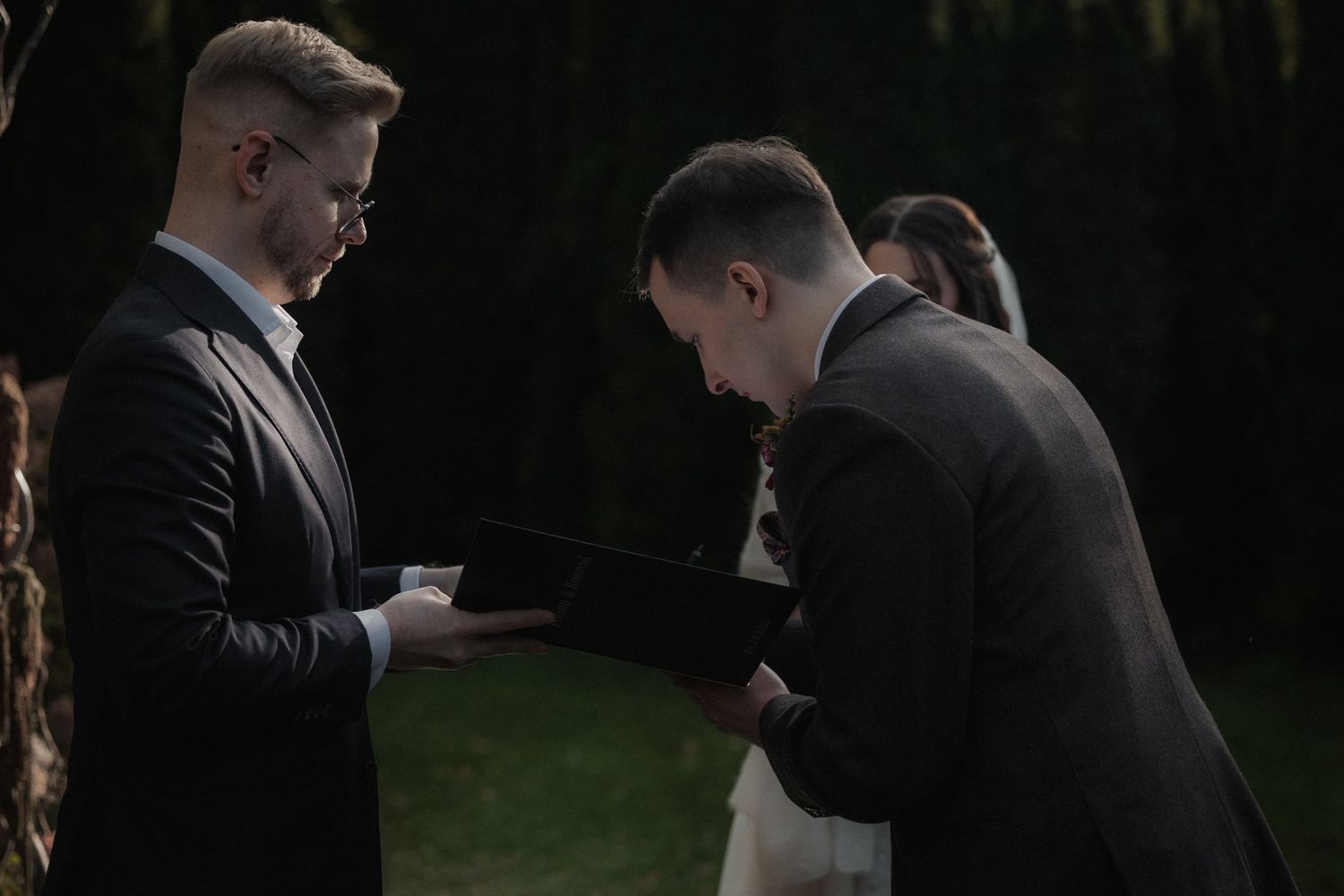 A couple in formal attire shares a romantic moment while dancing at an outdoor evening celebration.