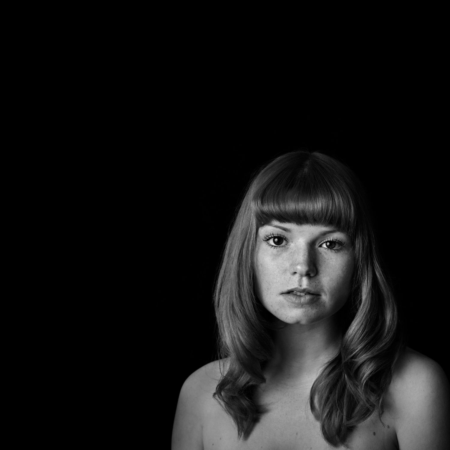 Portrait of a lady with a minimal style and in black and white. The lady is looking at the camera while having a photo session Ross-on-Wye