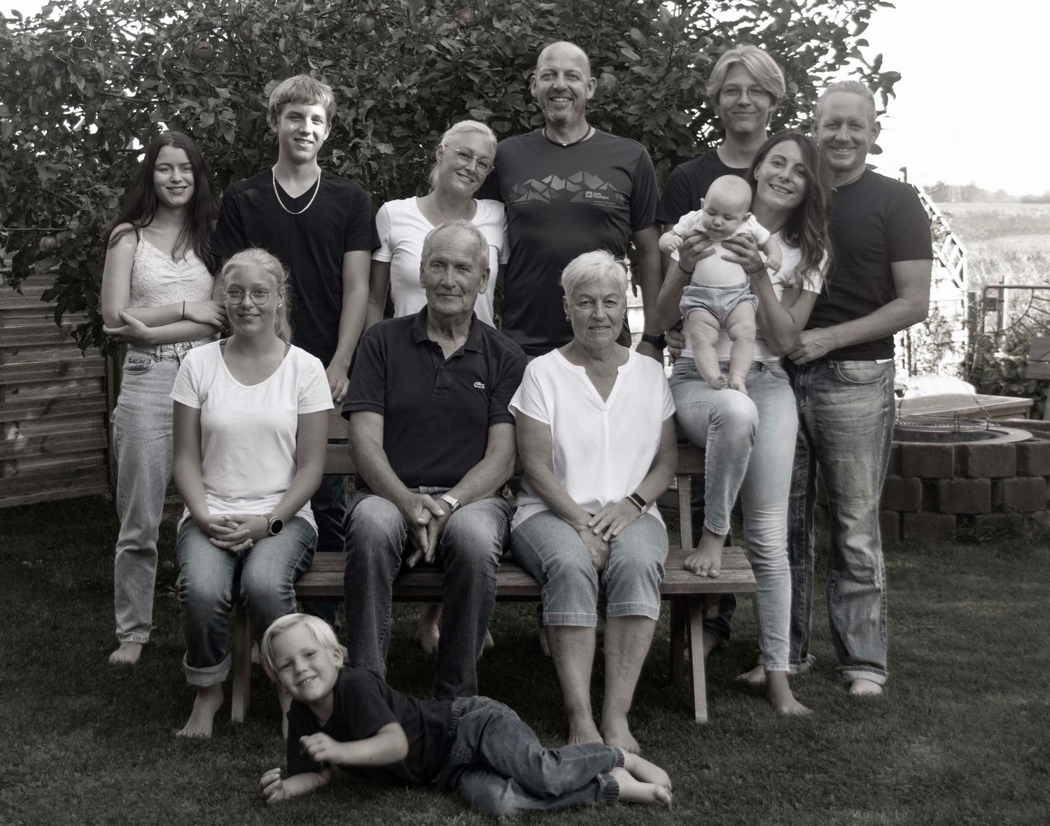 Natürliches Familienfoto mehrerer Generationen im Garten in Schwarzweiß
