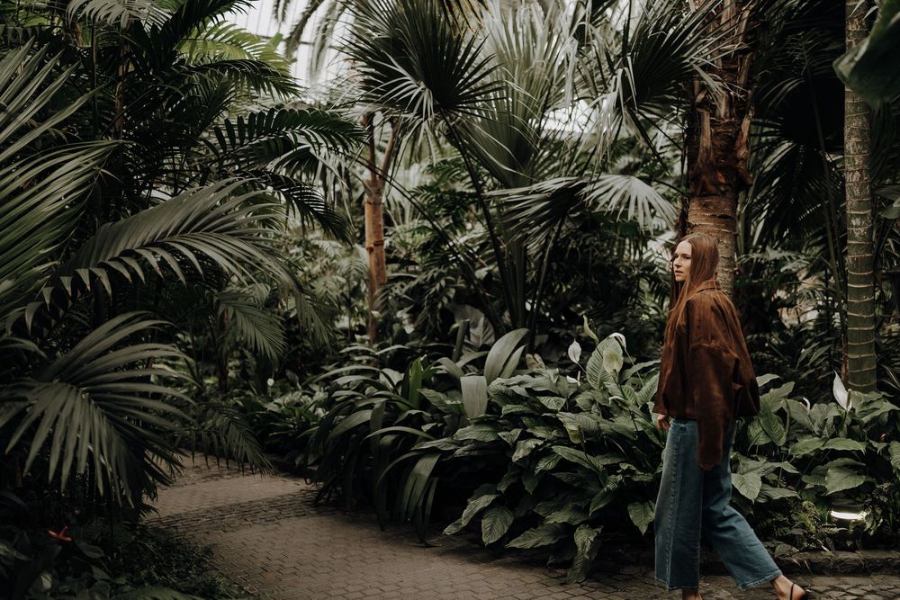 Frau läuft durch einen Palmengarten.