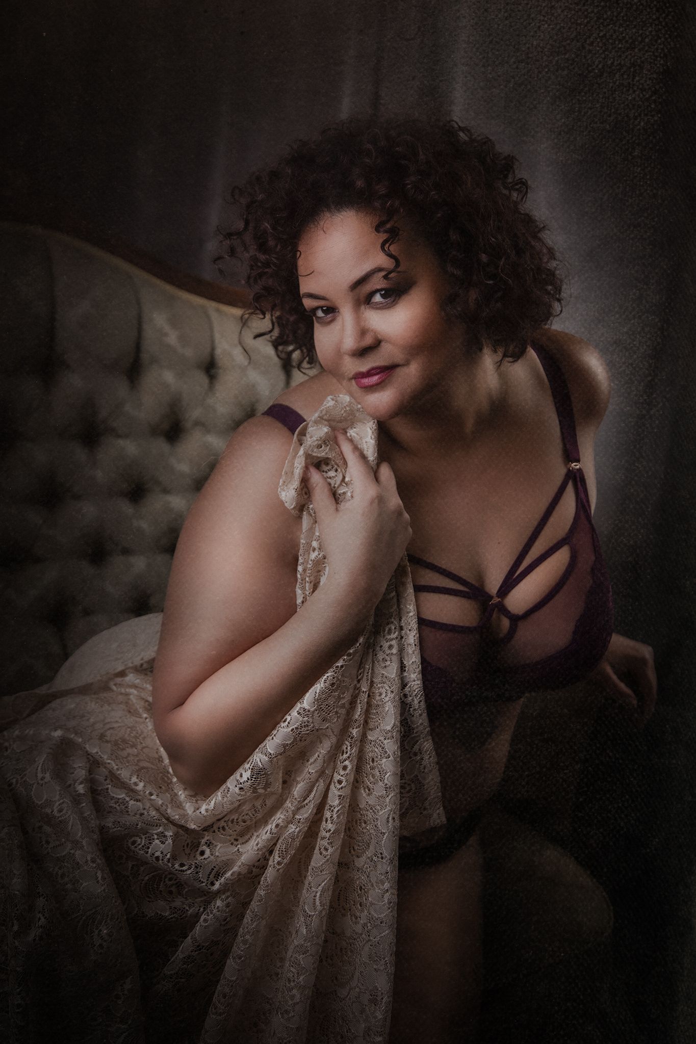 Moody boudoir photography featuring soft lighting and draped fabric.