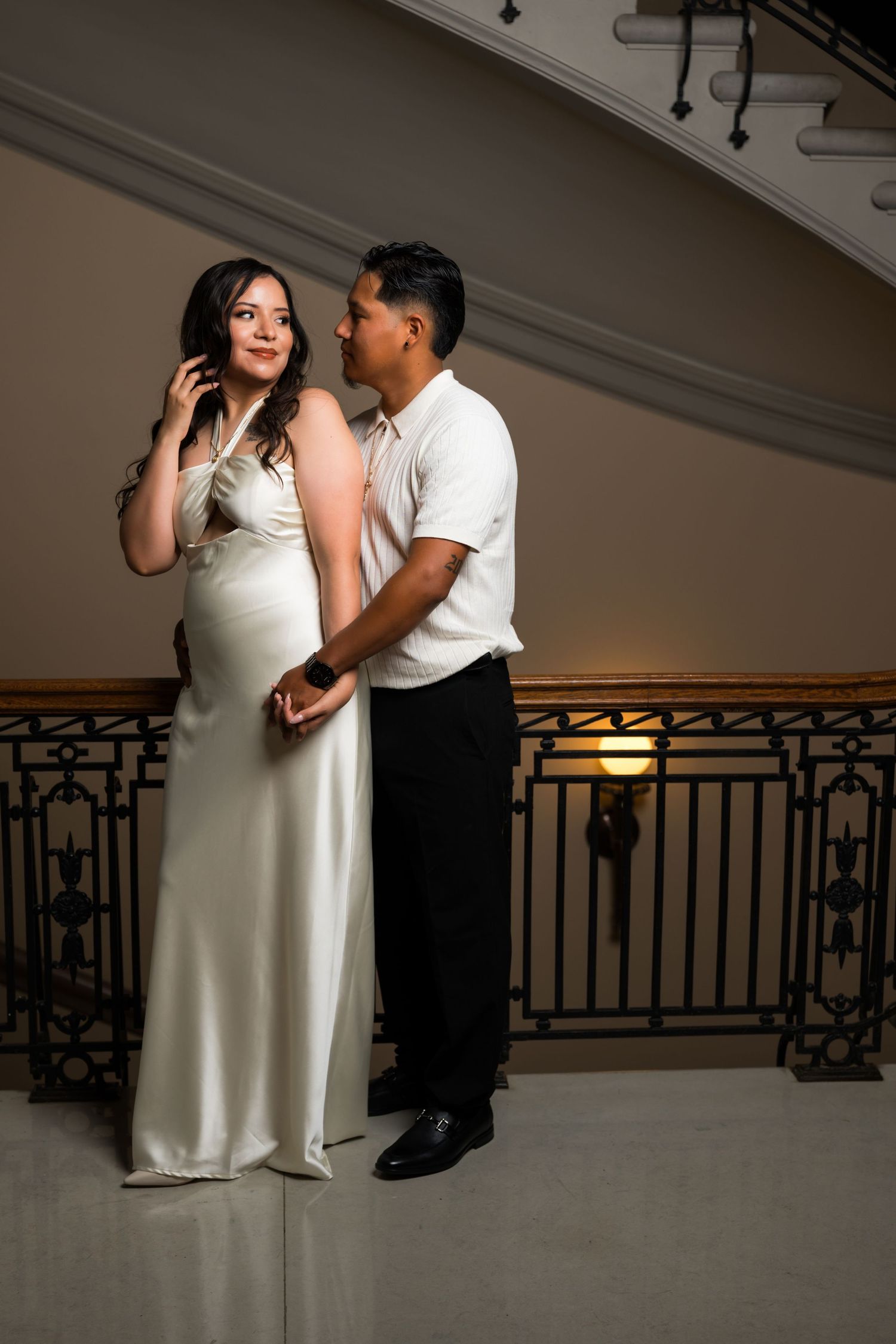A couple in contrasting black and white outfits share an intimate dance moment.