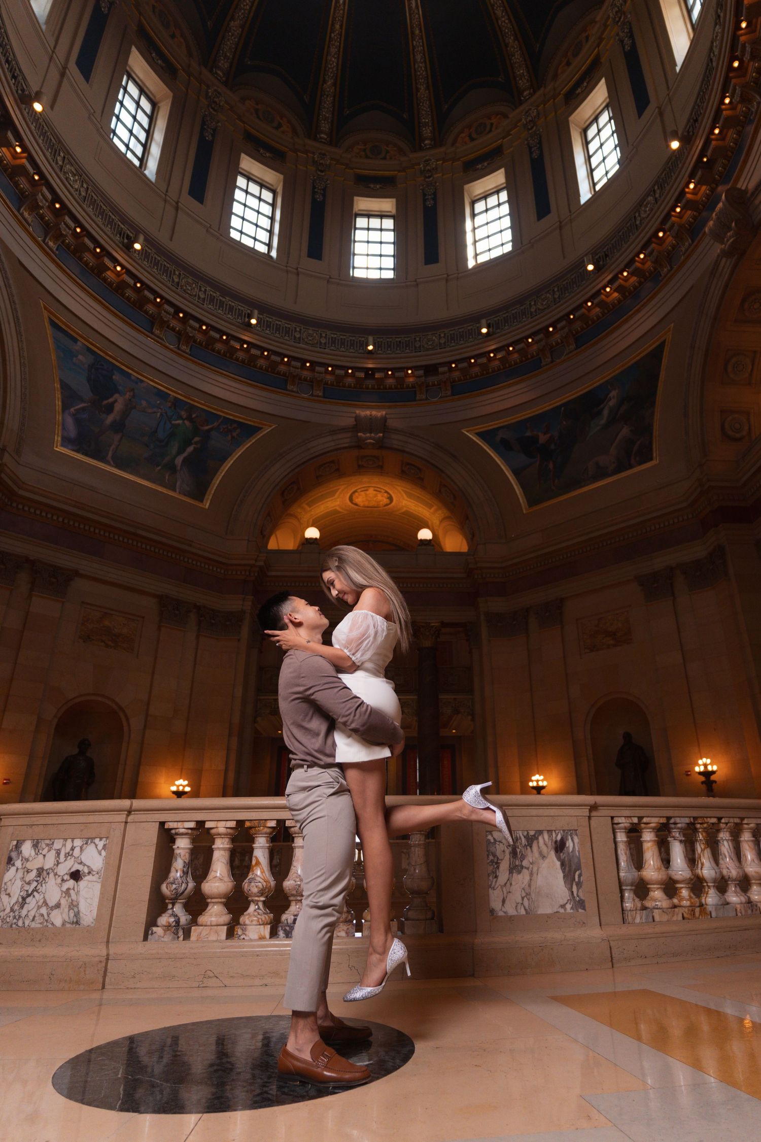 Romantic dance poses captured in a historic building with ornate architectural details.