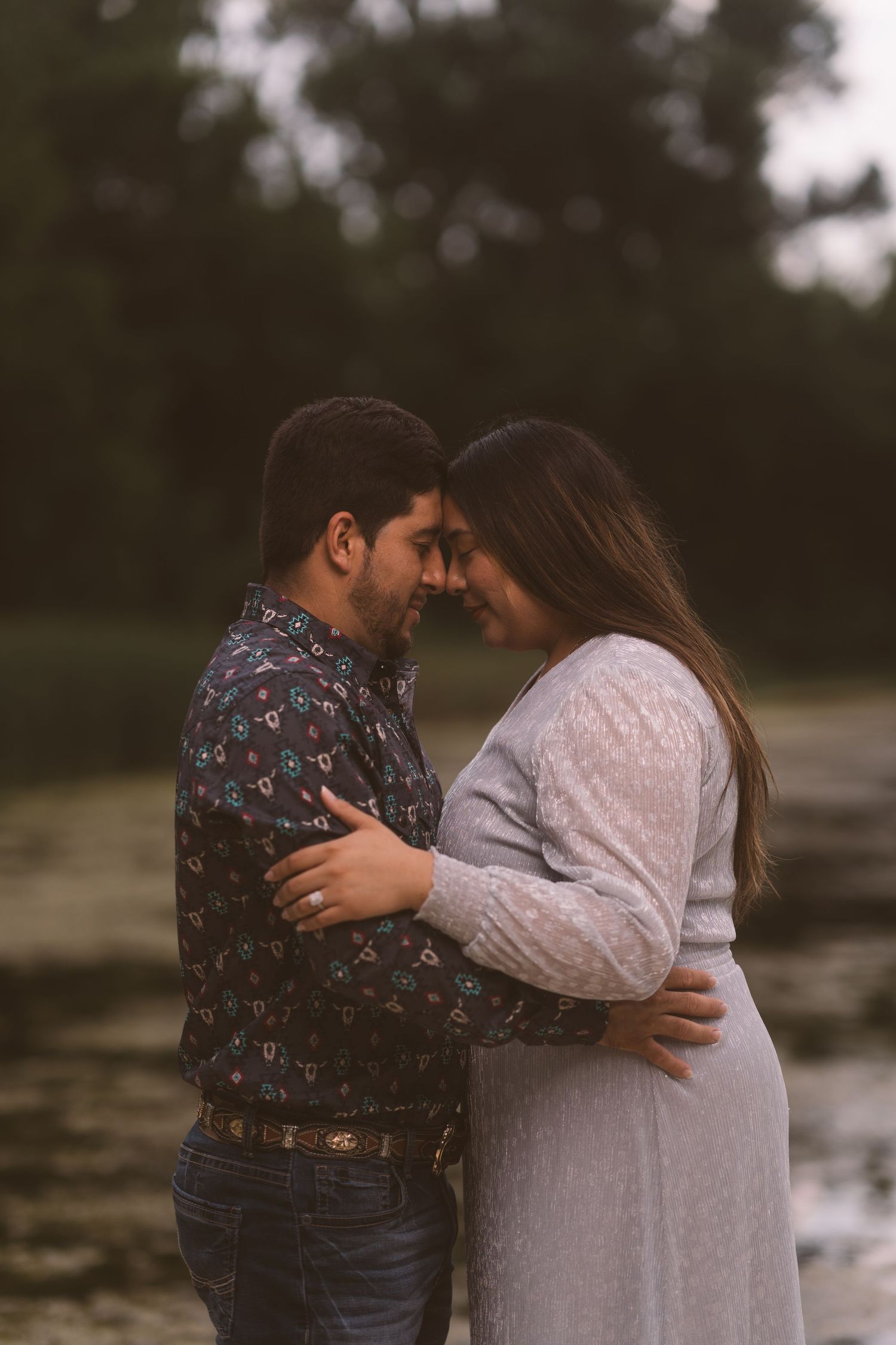 A couple embraces tenderly during a sunset photoshoot.