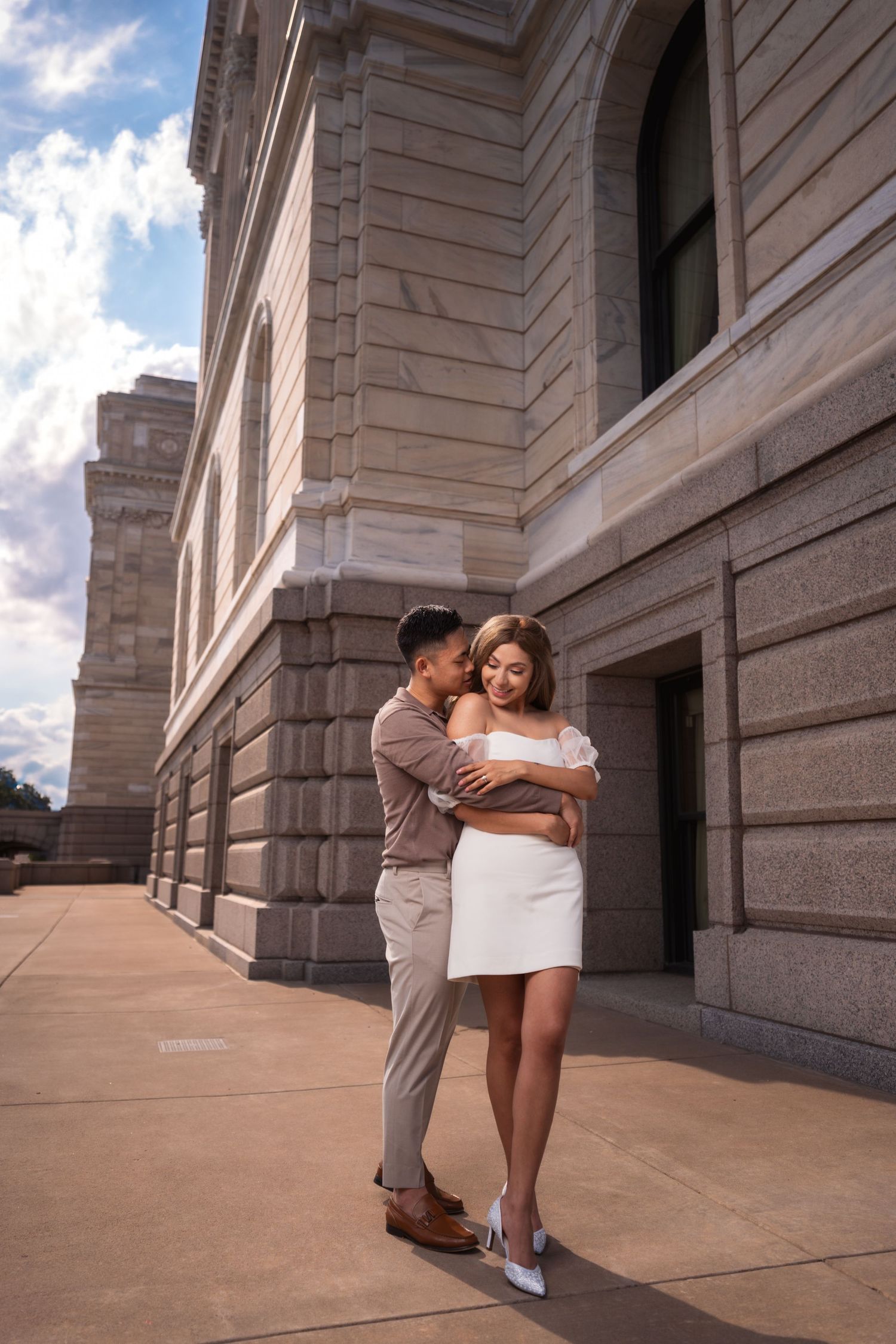 Romantic poses captured against the limestone facade of a historic building.