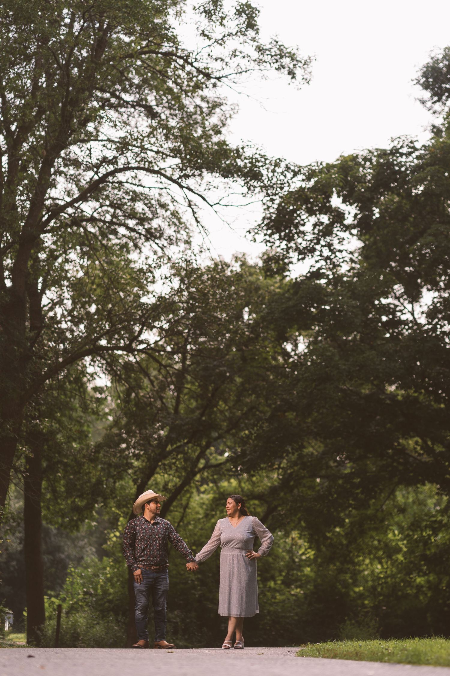 A couple dances together on a scenic wooded path.